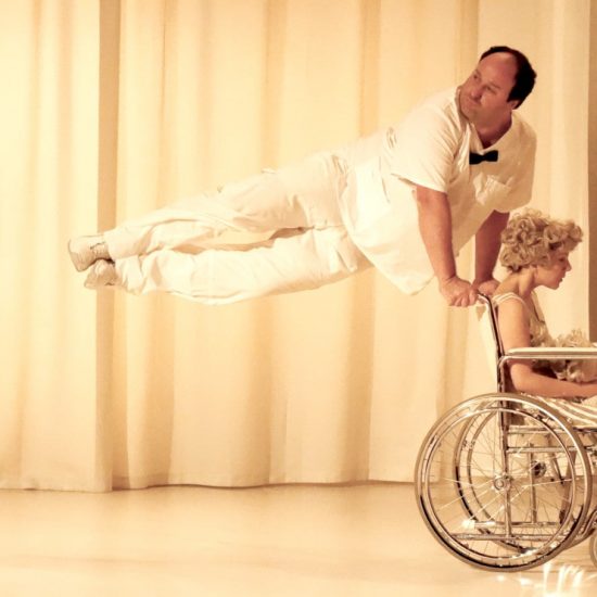Eric Gingras saute en s'appuyant sur la chaise roulante de Victoria, joué par Anne Sabourin